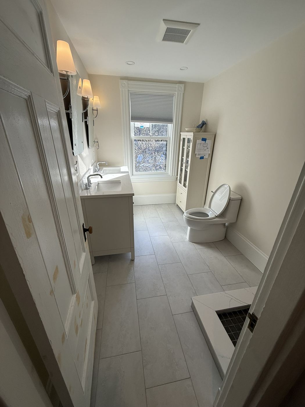 Finished bathroom with new vanity, toilet and tile floor